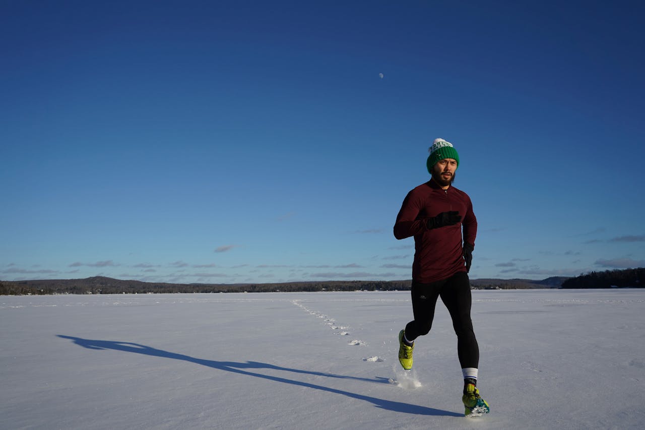 A runner training outdoors on a snowy field, embracing the cold while following tips to prevent dry skin in winter.