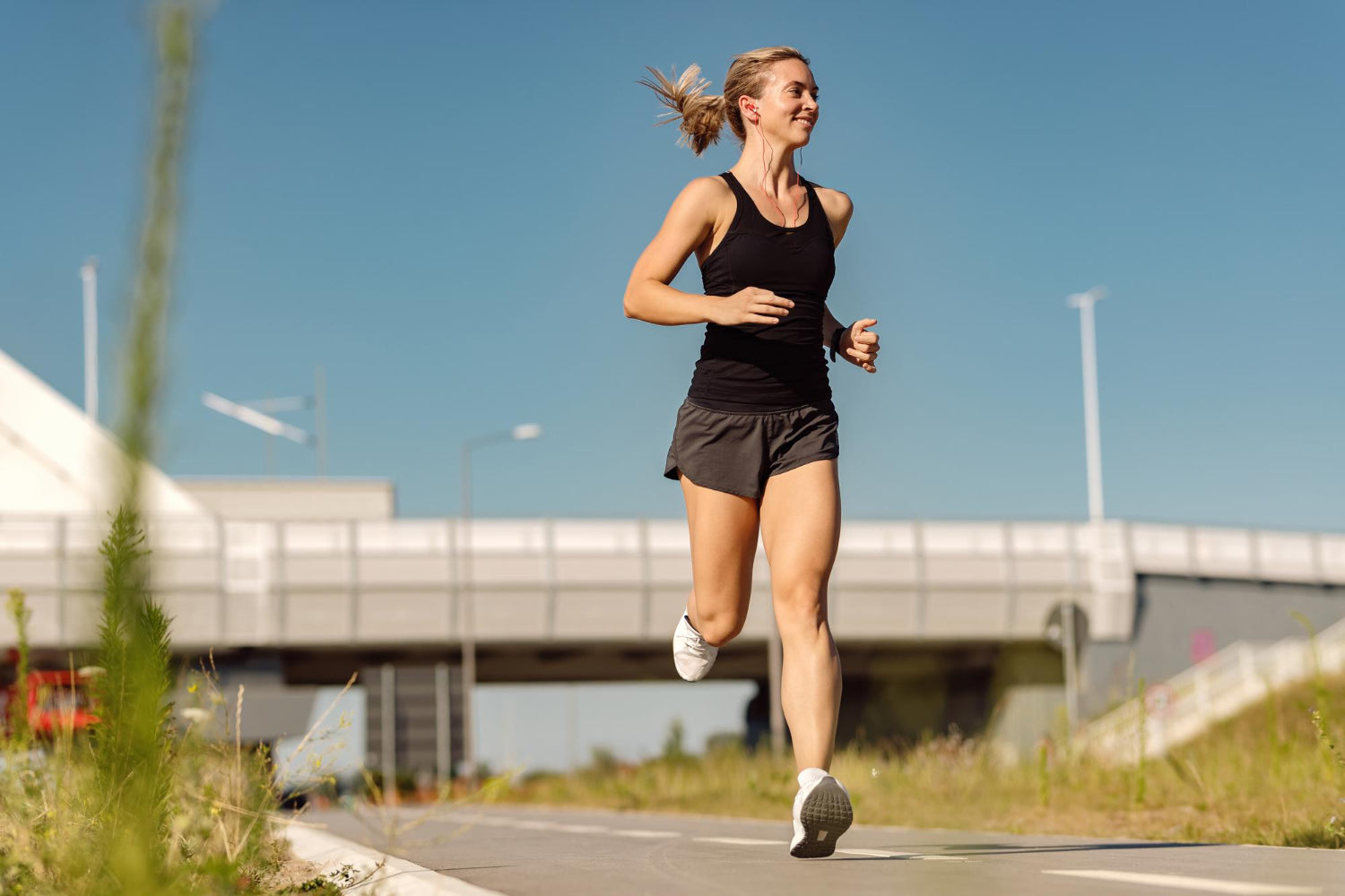 A woman runs on a roadway to demonstrate how to breathe while running