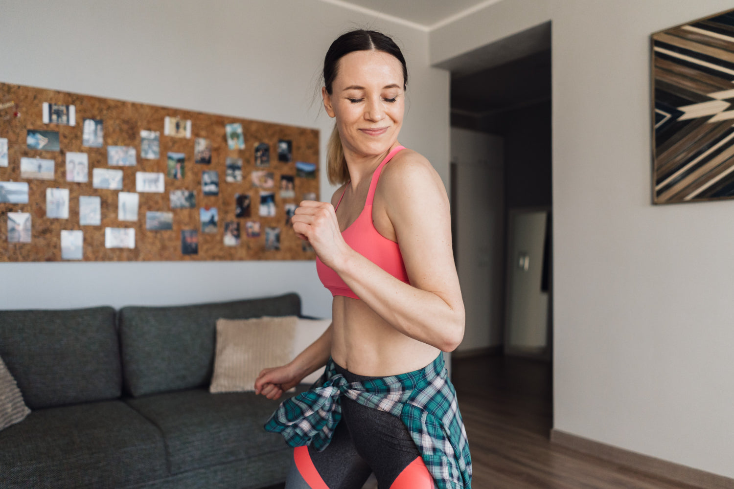 Woman dancing at home in activewear.