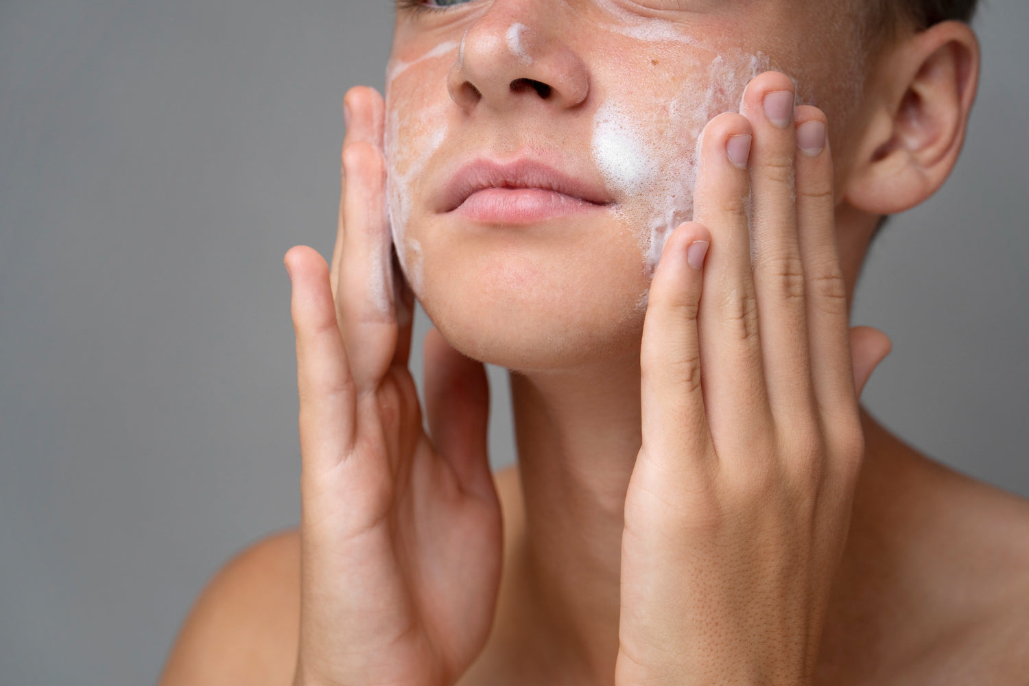 Person applying cleanser for skin exfoliation on their face.